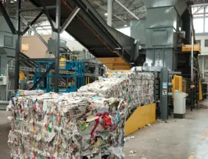 Paper bales being produced by a baler machine at Gillmoss Materials Recovery Facility