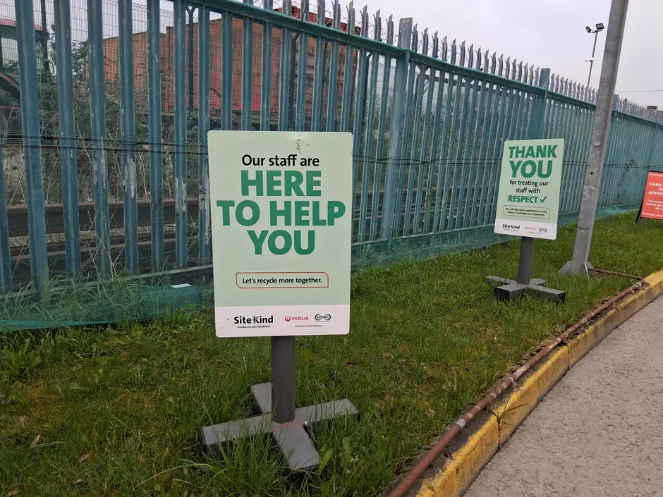 An outdoor sign with the text "Here to help you"