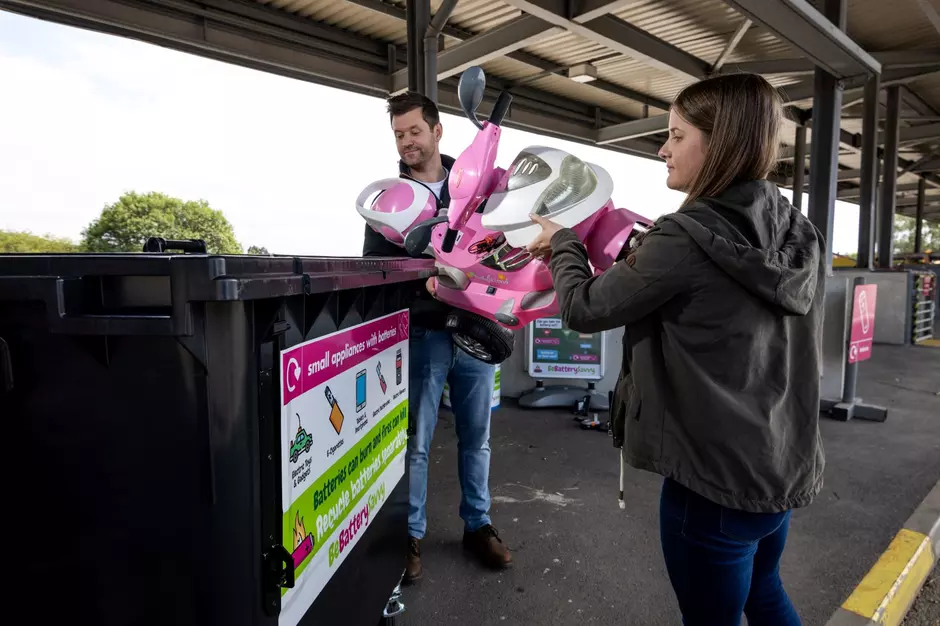 two people recycling electrical items and toys at the recycling centre in Merseyside
