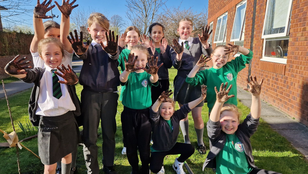 Children waving hands with Veolia staff at a orchard planting session